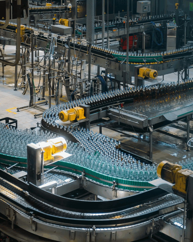 Transportband met glazen flessen en industriële automatisering.