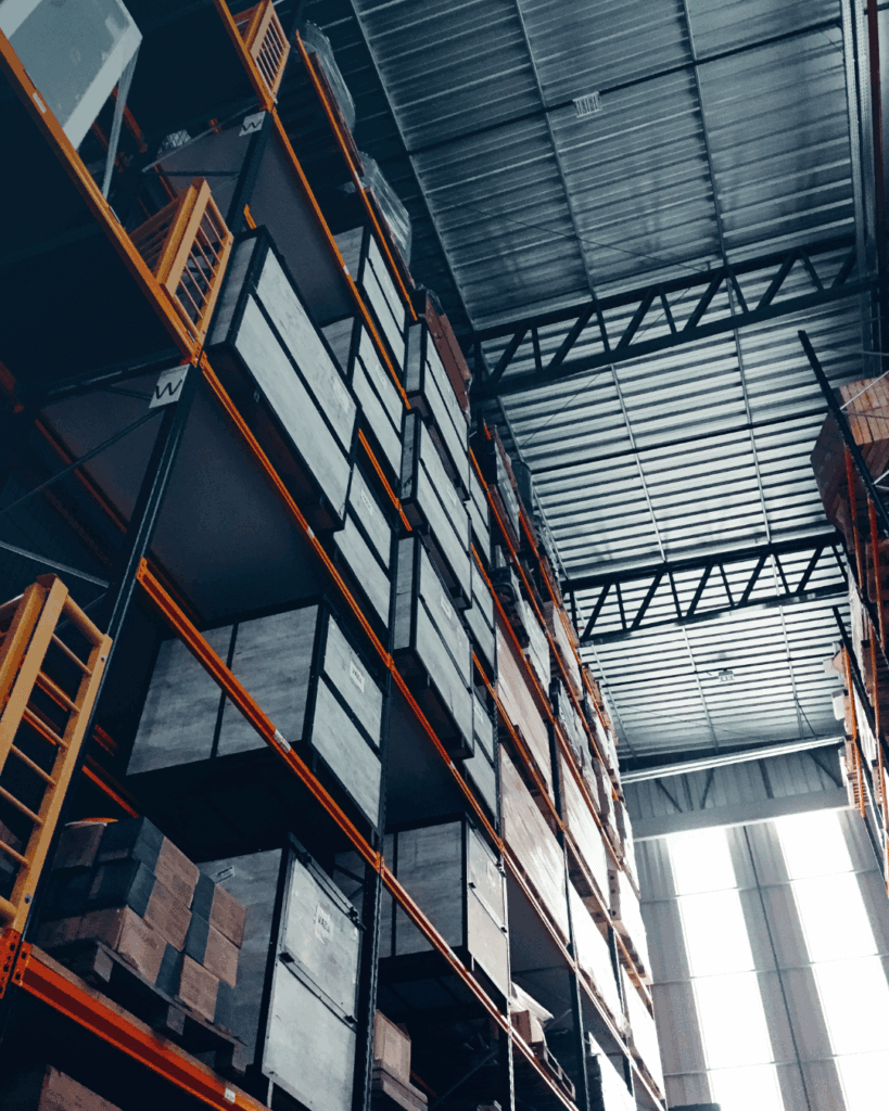 Opslagrekken met pallets en kratten in logistiek centrum.